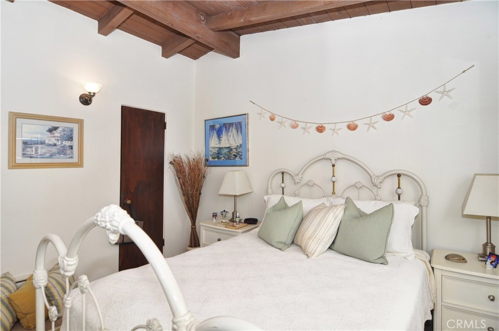 217 10th Street, Unit 4 Seal Beach, CA 90740 - Photo 34 of 45 a bedroom with a bed and a lamp with the view of entryway
