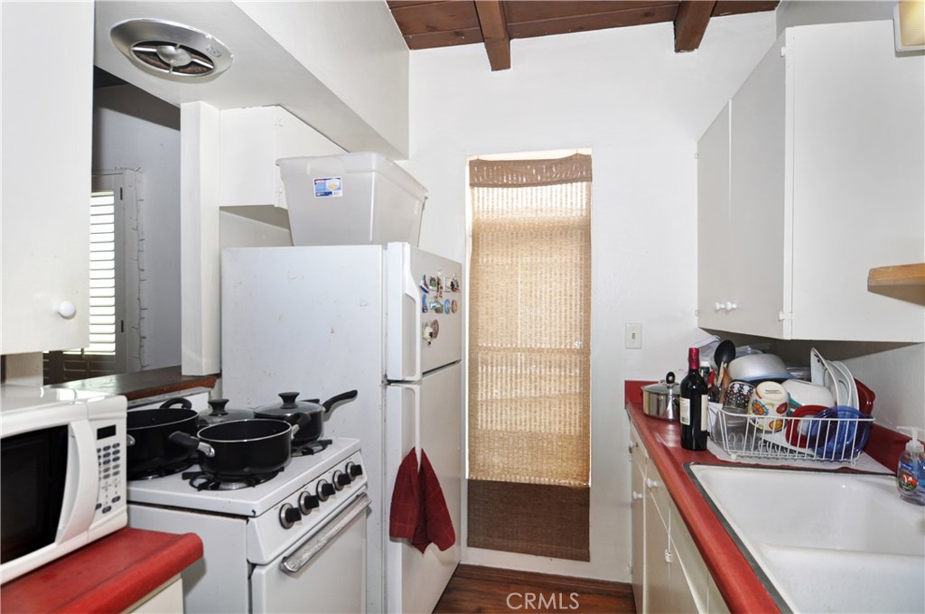 217 10th Street, Unit 4 Seal Beach, CA 90740 - Photo 40 of 45 a kitchen with a refrigerator and a stove top oven