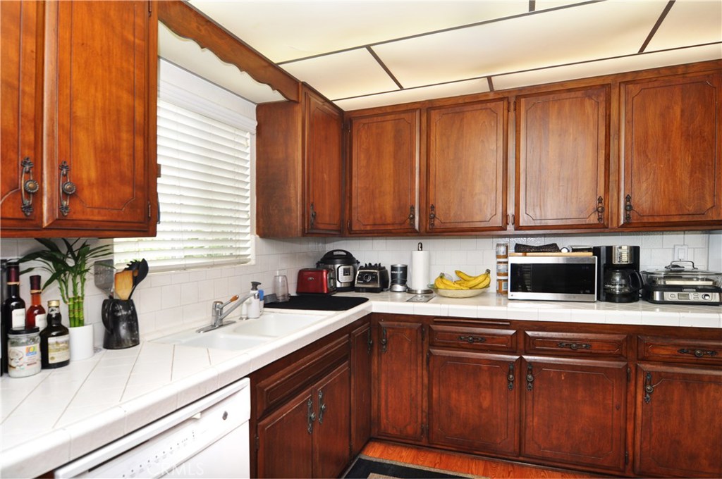 217 10th Street, Unit 4 Seal Beach, CA 90740 - Photo 7 of 45 a kitchen with stainless steel appliances granite countertop a sink a stove cabinets and a counter top space