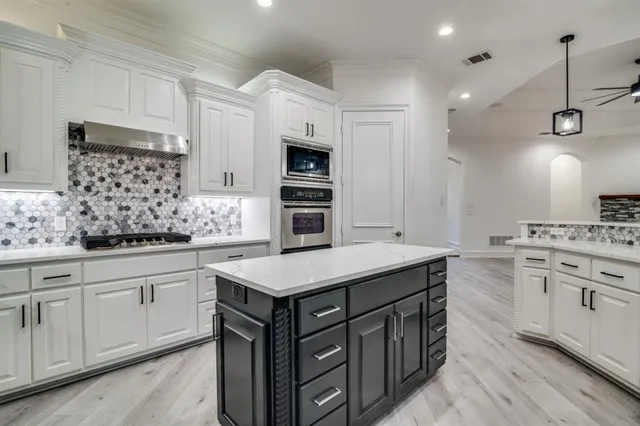 a kitchen with white cabinets and sink
