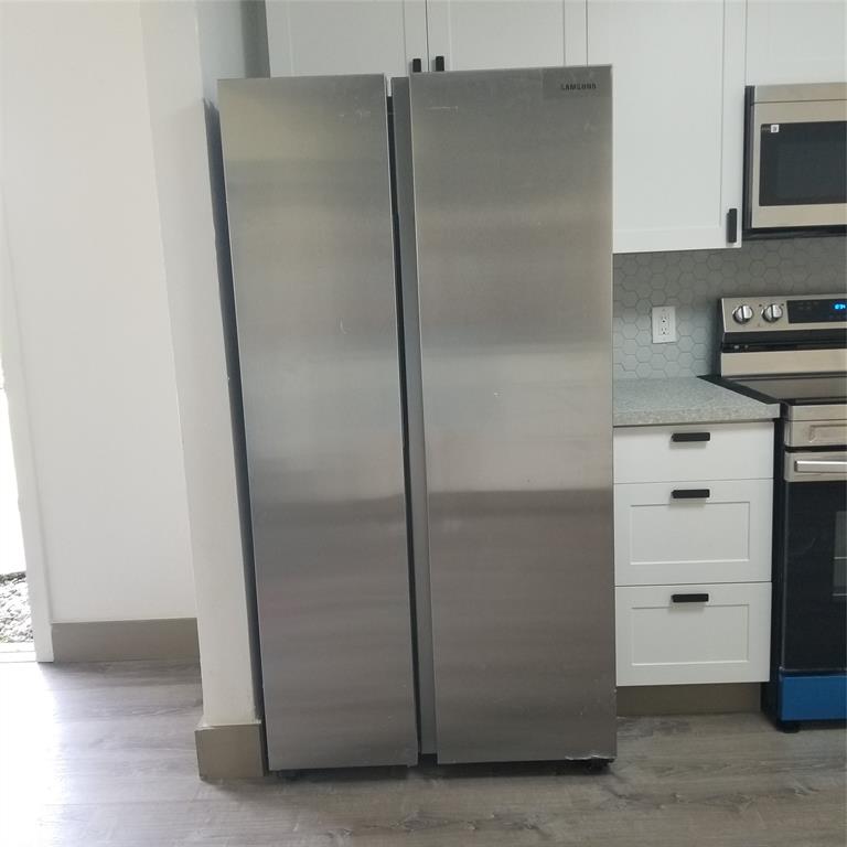 803 Northeast 8th Street Hallandale Beach, FL 33009 - Photo 20 of 38 a kitchen with a refrigerator and a stove