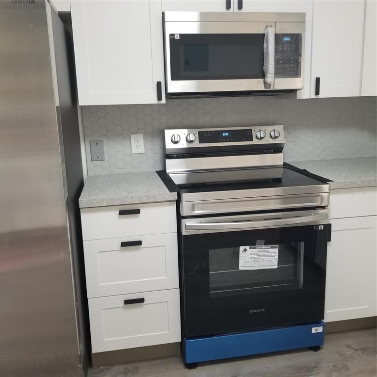 803 Northeast 8th Street Hallandale Beach, FL 33009 - Photo 21 of 38 a kitchen with a stove and a microwave