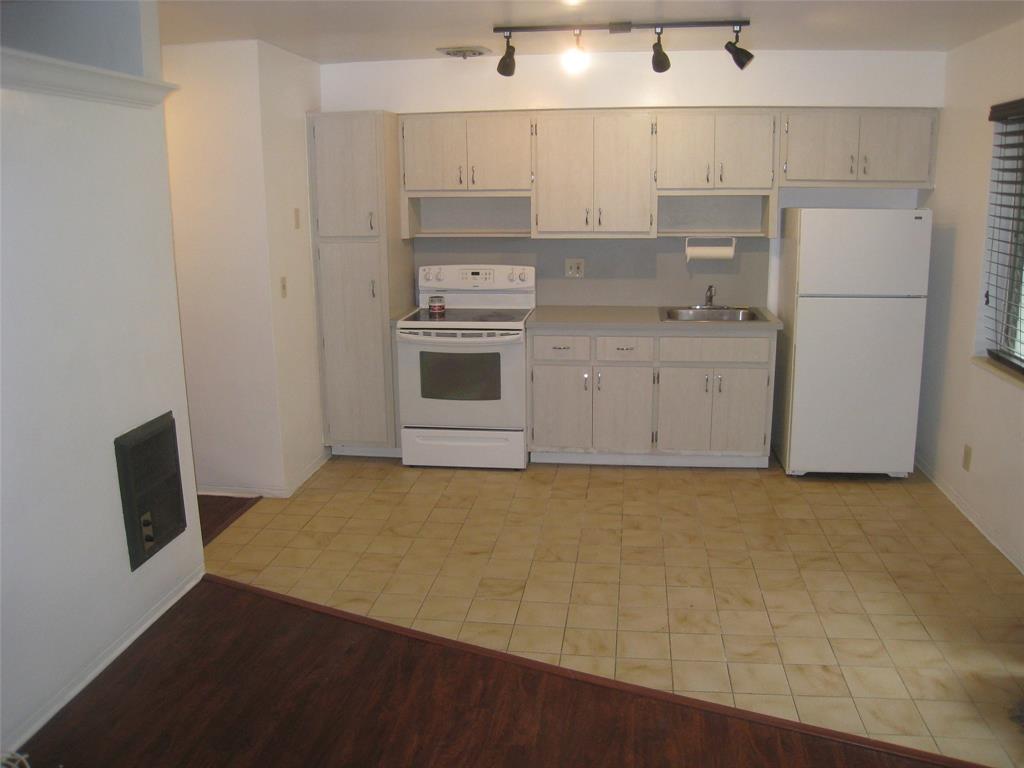 803 Northeast 8th Street Hallandale Beach, FL 33009 - Photo 26 of 38 a kitchen with a refrigerator stove and white cabinets