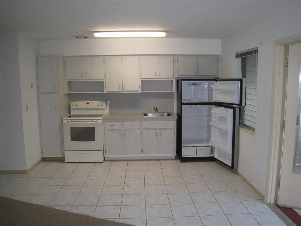803 Northeast 8th Street Hallandale Beach, FL 33009 - Photo 32 of 38 a kitchen with a stove a refrigerator and a sink