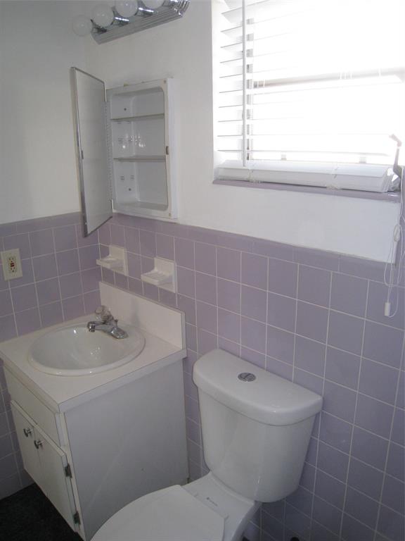 803 Northeast 8th Street Hallandale Beach, FL 33009 - Photo 34 of 38 a bathroom with a sink a toilet and a mirror