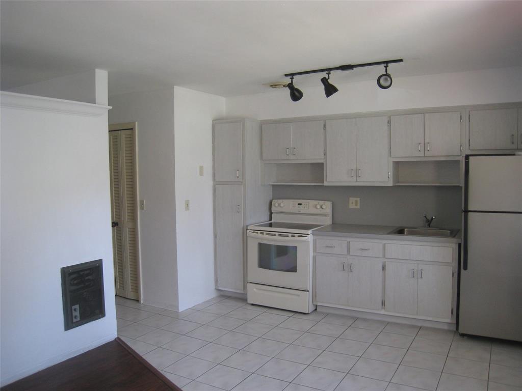 803 Northeast 8th Street Hallandale Beach, FL 33009 - Photo 35 of 38 a kitchen with white cabinets and white appliances