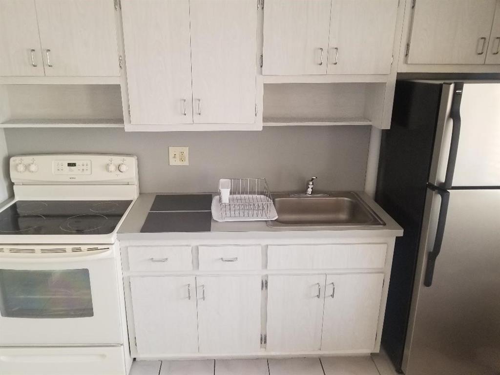 803 Northeast 8th Street Hallandale Beach, FL 33009 - Photo 36 of 38 a kitchen with white cabinets and sink