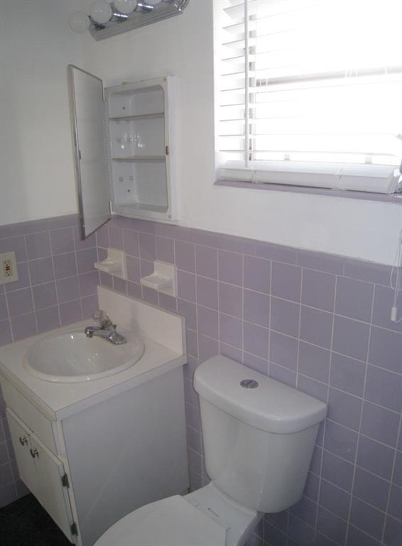 803 Northeast 8th Street Hallandale Beach, FL 33009 - Photo 37 of 38 a bathroom with a sink a toilet and a mirror