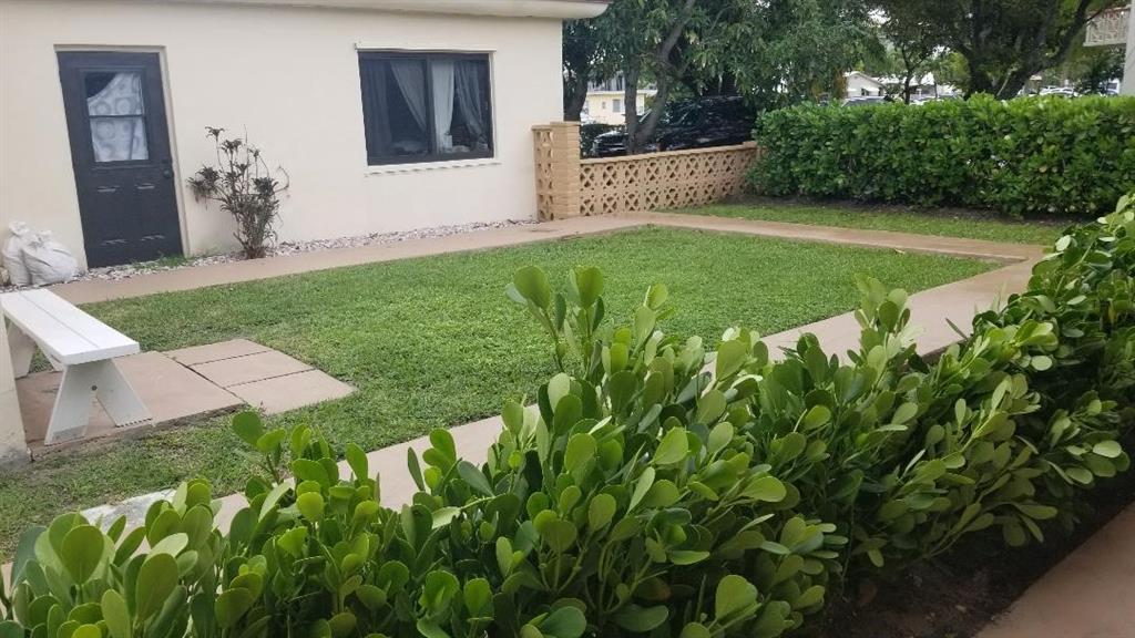 803 Northeast 8th Street Hallandale Beach, FL 33009 - Photo 8 of 38 a front view of a house with a yard