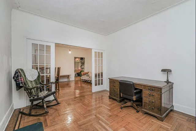 a living room with a bed and a book shelf