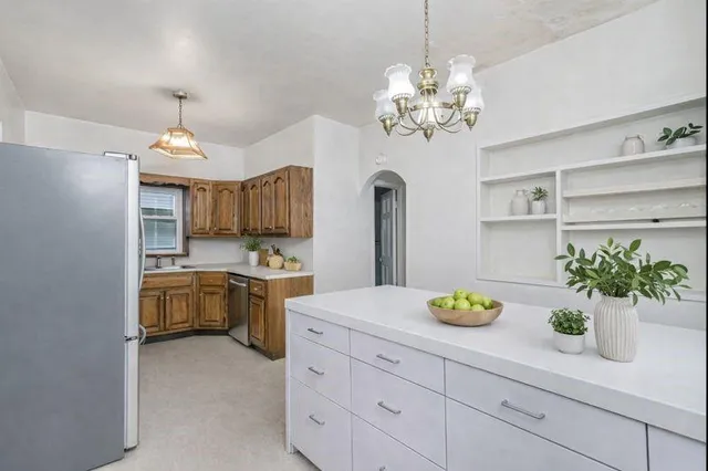 a kitchen with stainless steel appliances granite countertop a refrigerator stove and sink