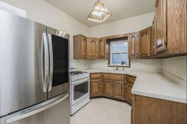 a kitchen with stainless steel appliances a stove a refrigerator and cabinets
