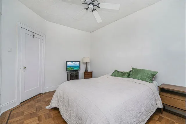 a bedroom with a bed and a lamp next to a window