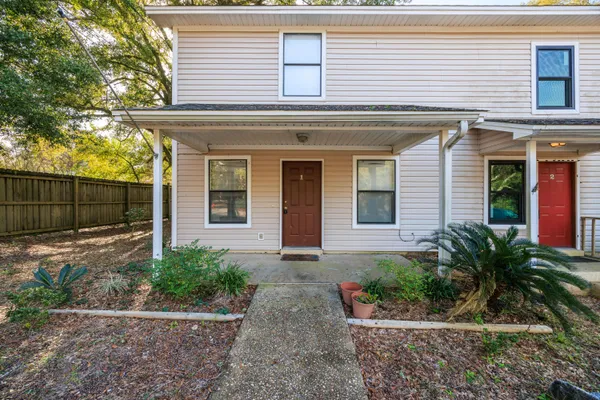 a front view of a house with garage and plants