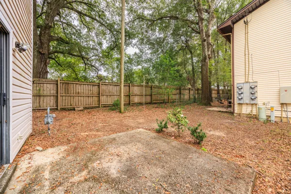 a view of a house with backyard and a tree