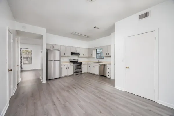 a kitchen with cabinets and wooden floor