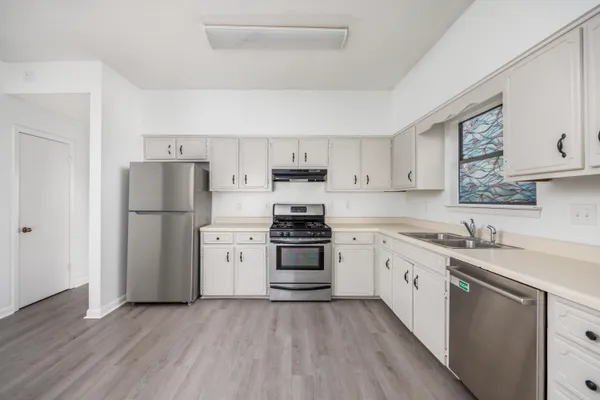 a kitchen with stainless steel appliances granite countertop a refrigerator stove a sink and dishwasher with wooden floor