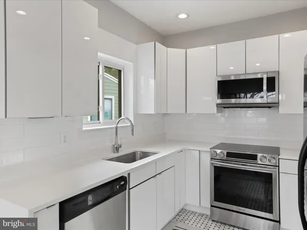 a kitchen with white cabinets stainless steel appliances and sink