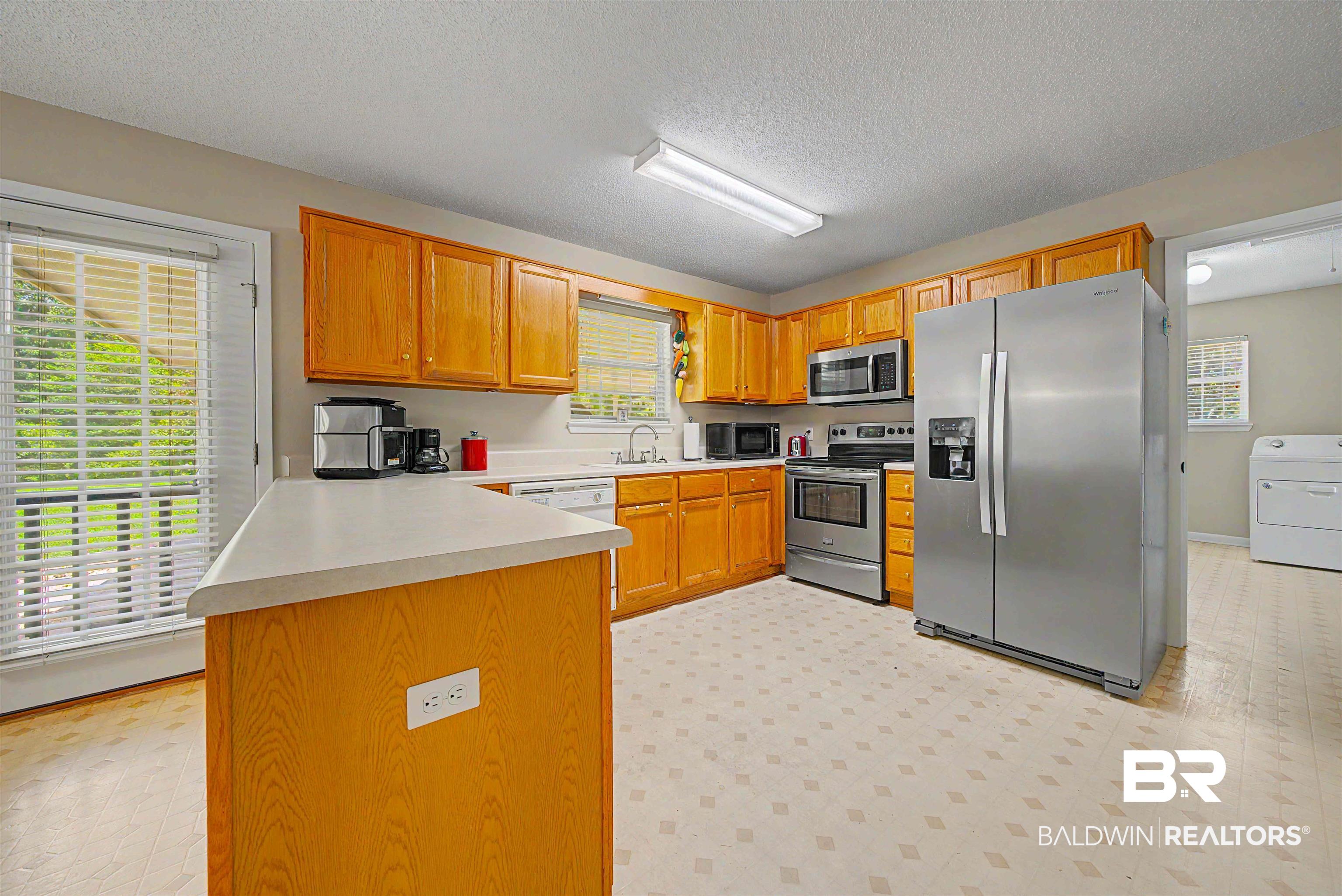 22963 Highway 98 Foley, AL 36535 - Photo 12 of 52 Kitchen featuring wood cabinetry, stainless steel appliances, and a central island with countertop space