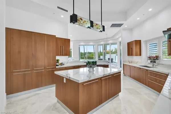 a kitchen with kitchen island a counter top space appliances and a sink