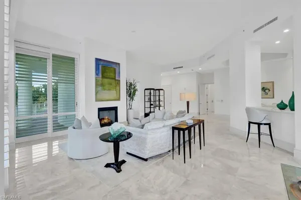 a living room with furniture a fireplace and a large window
