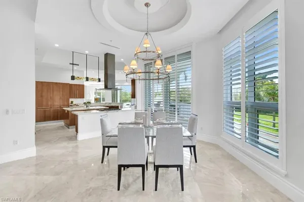 a dining room with furniture a chandelier and window