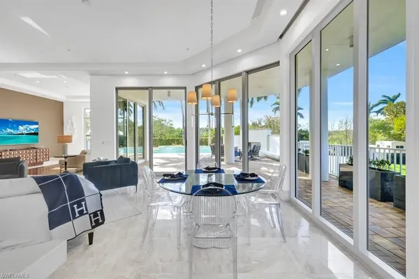 a living room with furniture and floor to ceiling windows
