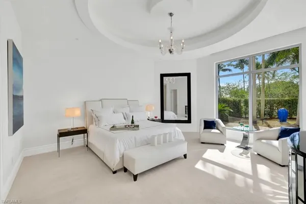 a spacious bedroom with a bed and a chandelier