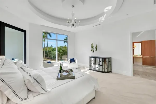 a living room with furniture large window and a chandelier