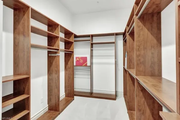 a view of walk in closet with clothes and shoes