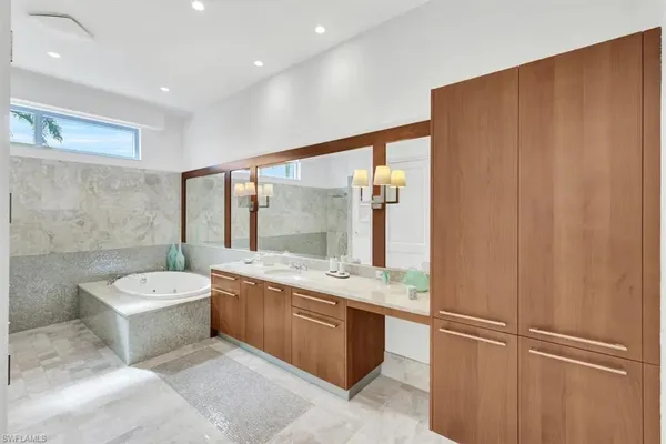 a spacious bathroom with a double vanity sink a mirror and a bathtub