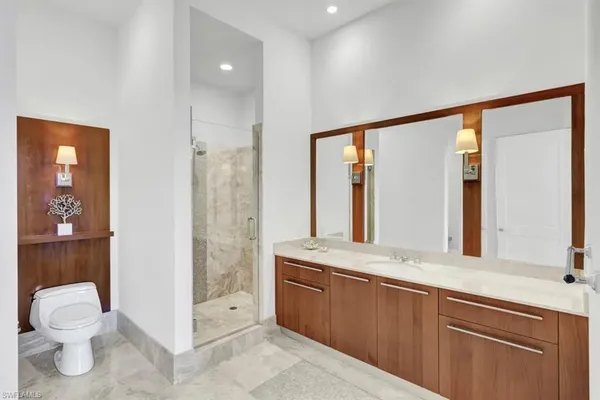 a bathroom with a toilet a sink and a large mirror