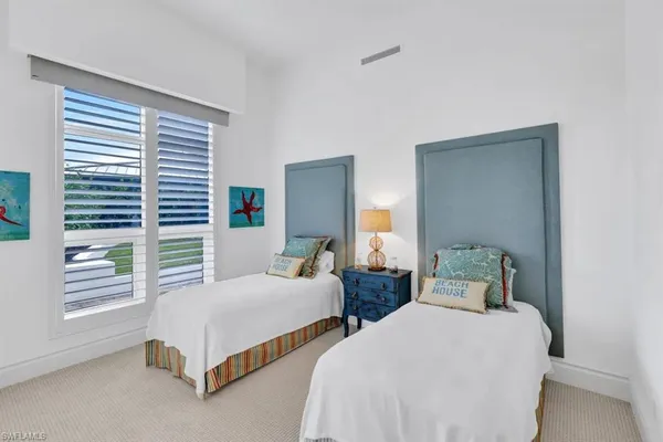 a bedroom with two beds and a window