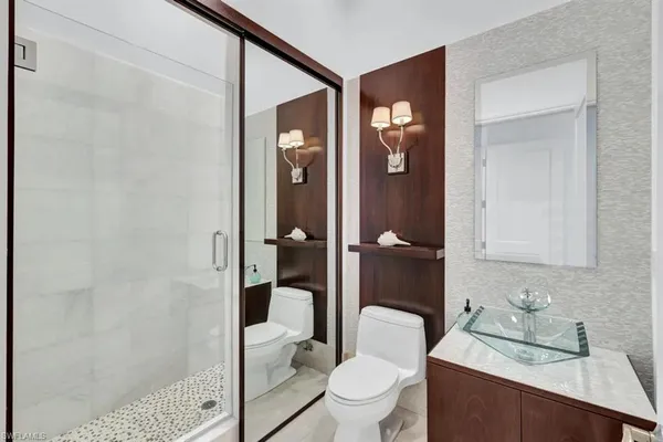 a bathroom with a sink a toilet and shower