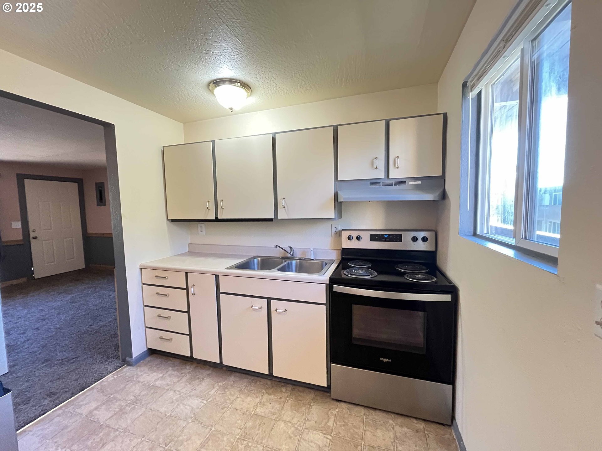 1260 10th Street, Unit 23 Florence, OR 97439 - Photo 15 of 19 a kitchen with stainless steel appliances a stove a sink and a microwave
