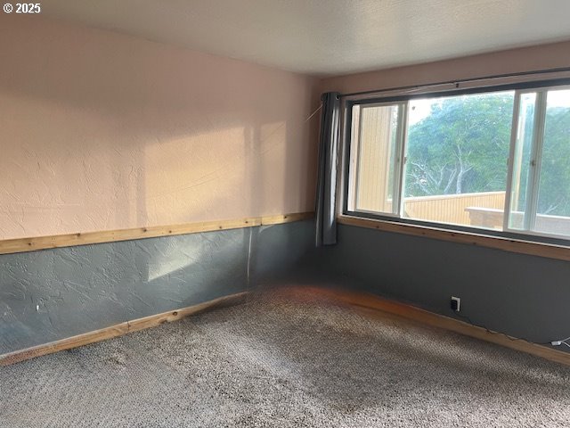 1260 10th Street, Unit 23 Florence, OR 97439 - Photo 6 of 19 an empty room with wooden floor and windows