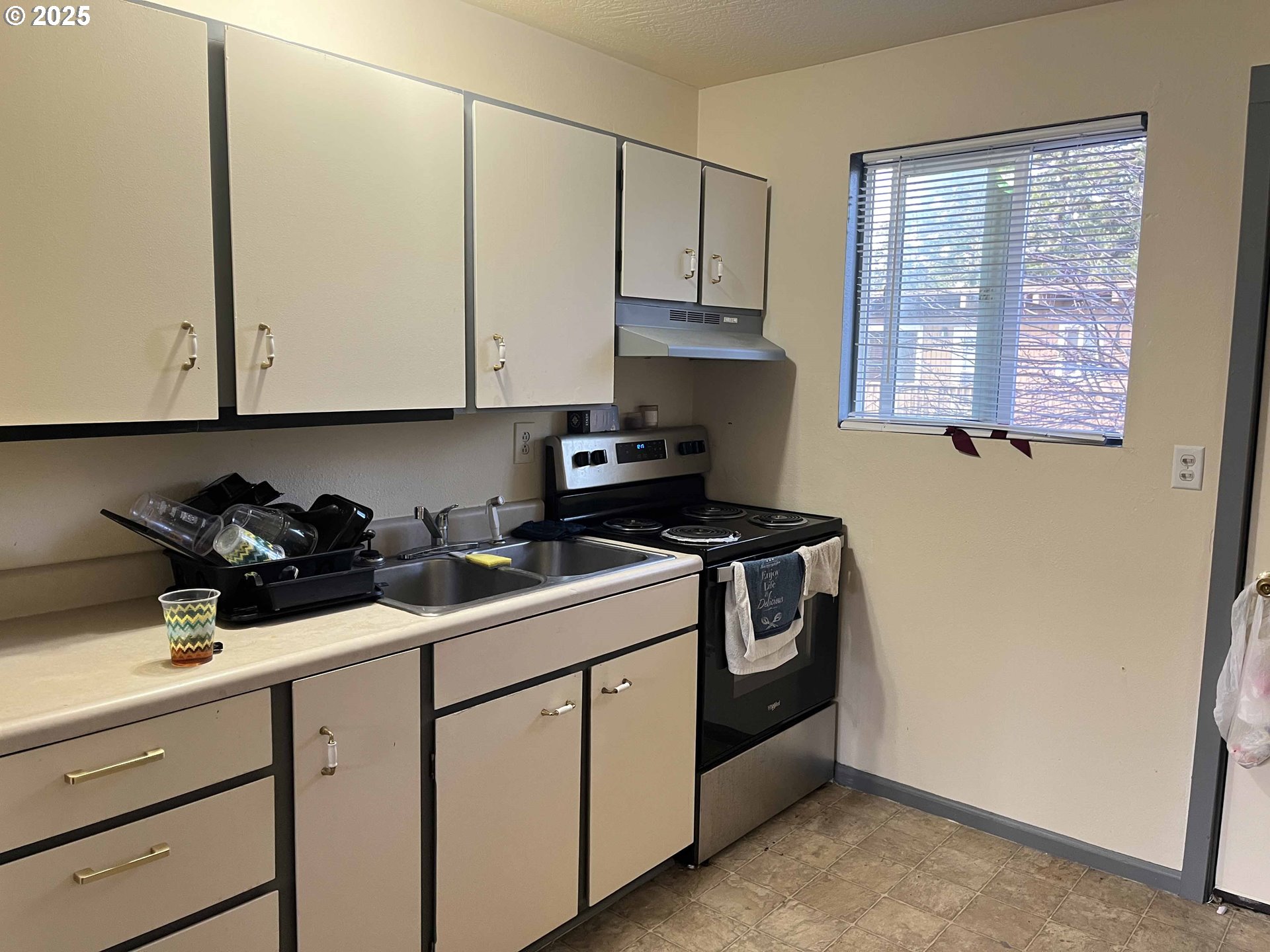 1260 10th Street, Unit 23 Florence, OR 97439 - Photo 8 of 19 a kitchen with stainless steel appliances granite countertop white cabinets sink and window