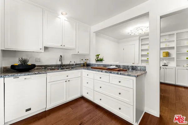 a kitchen with granite countertop cabinets stainless steel appliances and a wooden floor