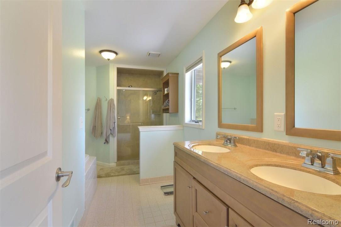 6415 Hogan Road Fenton, MI 48430 - Photo 26 of 72 Master bathroom has 2 sinks, tub and separate shower