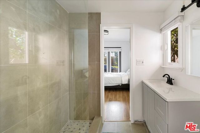 a en suite bathroom with a sink a mirror and a shower