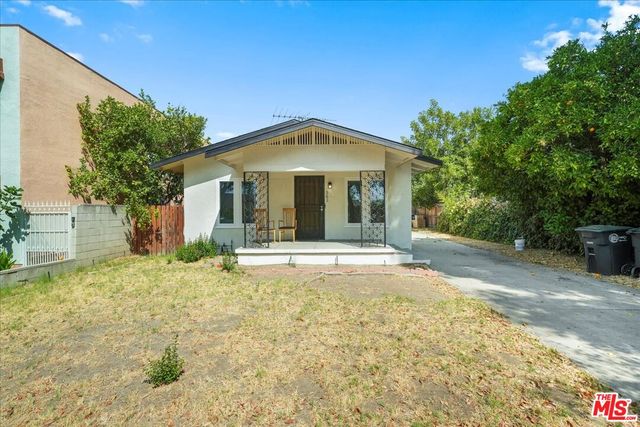 a view of a house with backyard and sitting area
