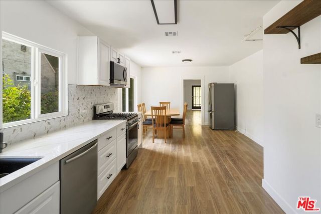 a kitchen with lots of counter top space and wooden floor