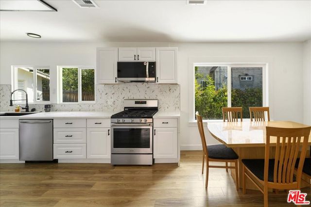 a kitchen with stainless steel appliances kitchen island granite countertop a stove a sink and a microwave