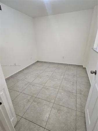 a view of a room with an empty space and a window