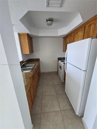 a kitchen with a refrigerator and a stove top oven