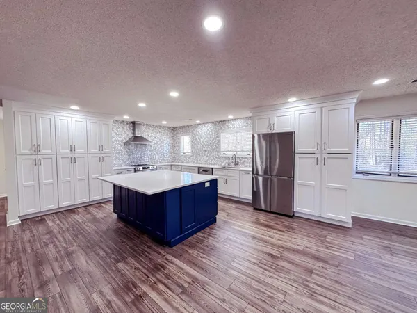 a kitchen with stainless steel appliances kitchen island wooden cabinets and wooden floors