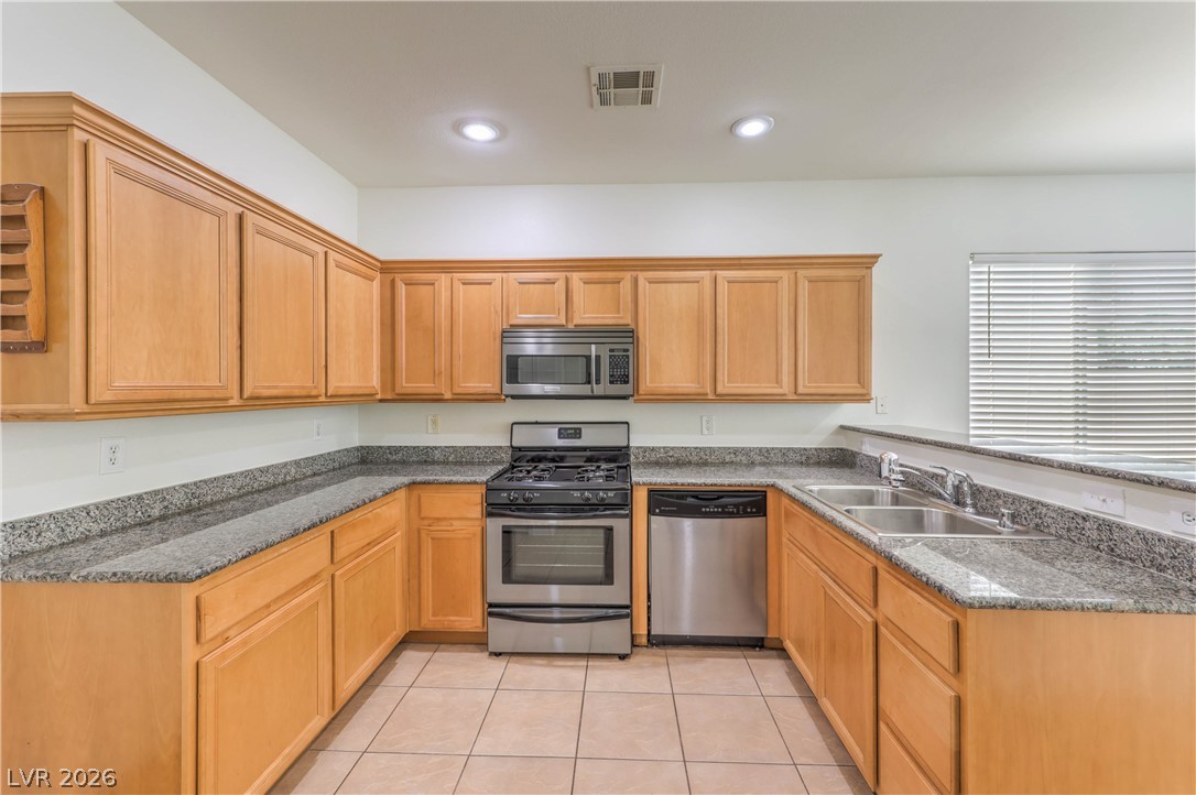 10939 Paradise Road Henderson, NV 89052 - Photo 6 of 36 A well-appointed kitchen features ample counter space, rich wood cabinetry, and recessed lighting.