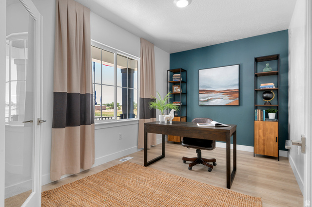 1418 West 2350th South, Unit 15 Perry, UT 84302 - Photo 3 of 22 Bright room featuring light wood-finish flooring, a full-lite interior door with brushed nickel hardware, and a large window with white trim