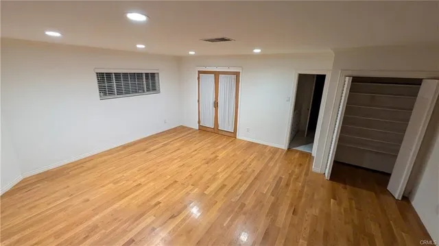 a view of empty room with wooden floor