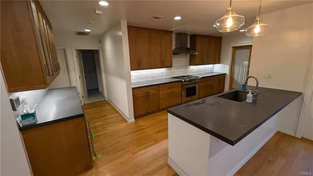 a kitchen with stainless steel appliances granite countertop a sink a stove and a refrigerator